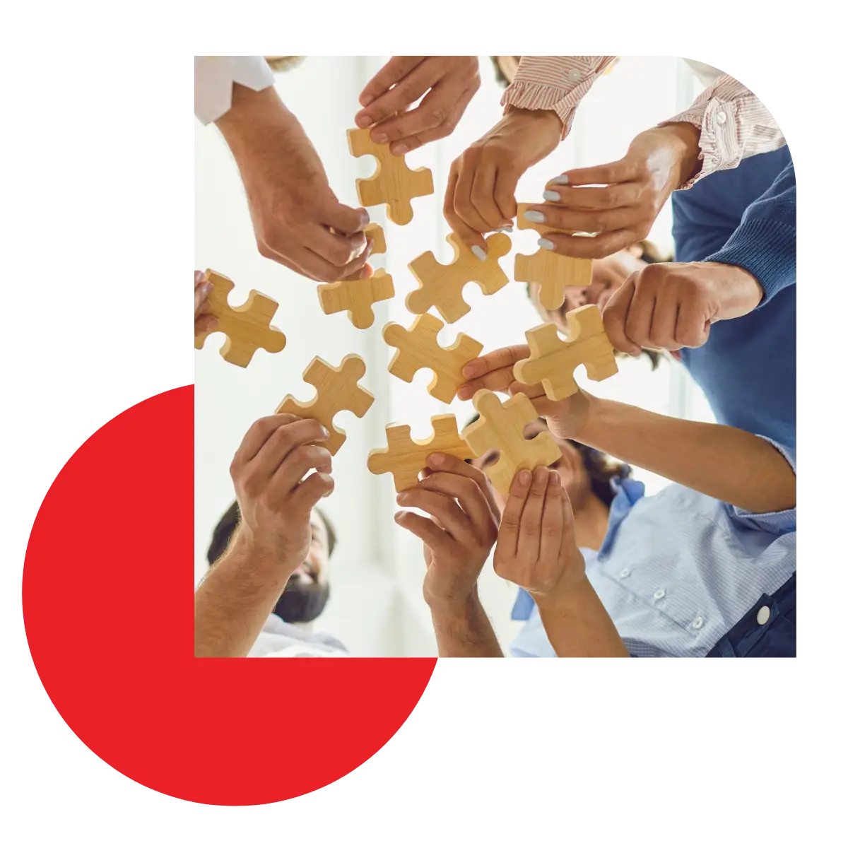 Group of hands holding wooden puzzle pieces together to symbolize building a team."