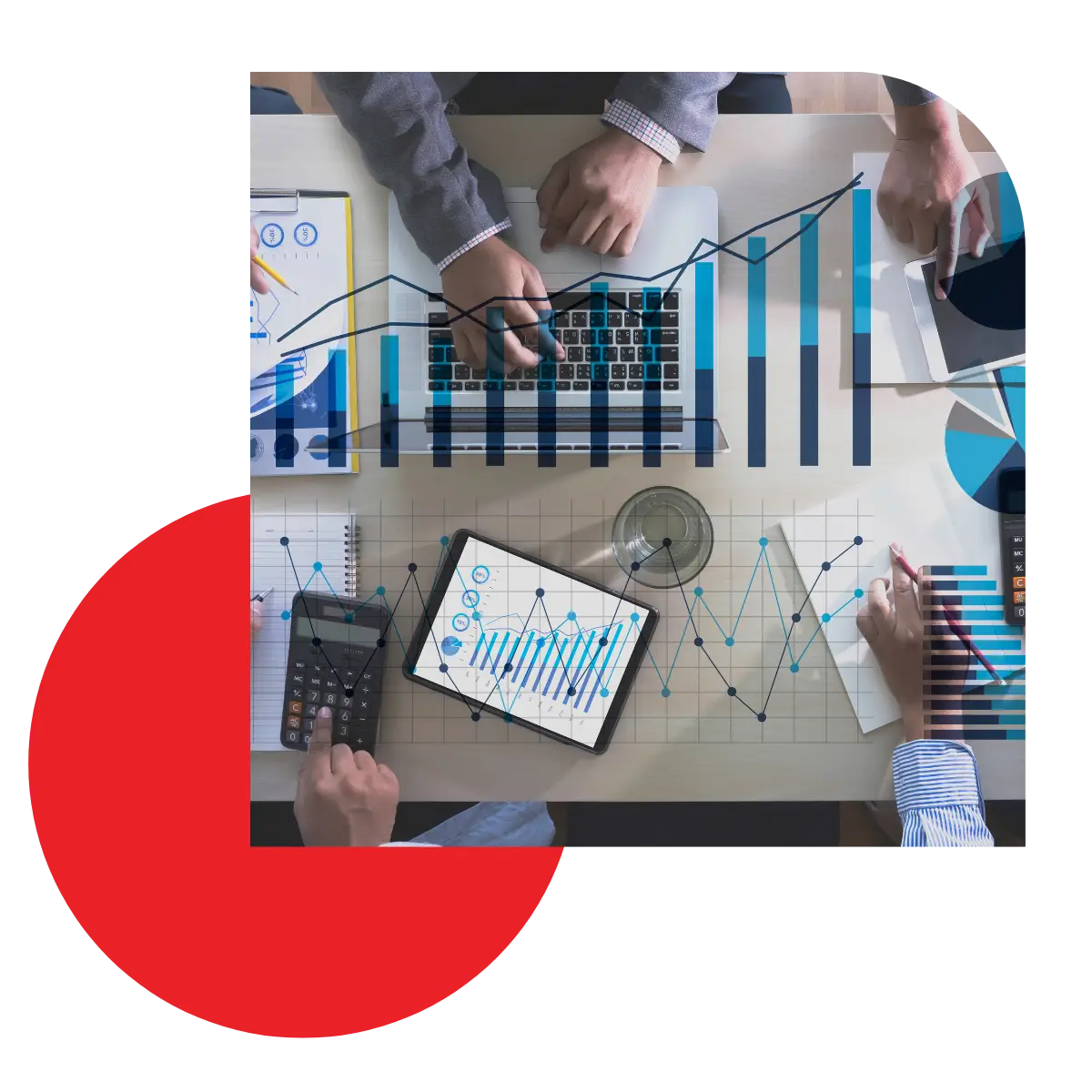 Overhead view of a workspace with digital charts overlaying the desk to illustrate sales, finance, and marketing analytics.